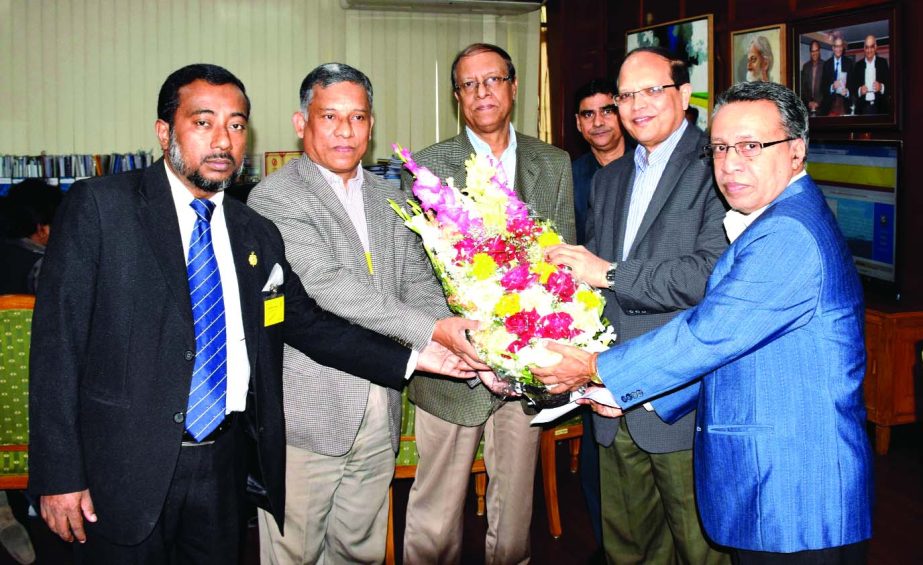 Md Shoaib Choudhury, Vice President of Dhaka Chamber of Commerce and Industry, presenting bouquet to Bangladesh Bank Governor Dr Atiur Rahman for being named the best central bank Governor in the Asia Pacific region at BB head office on Wednesday. DCCI Di