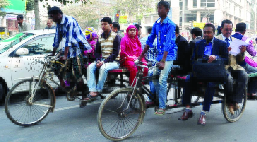 Commuters going to their destinations boarding on rickshaw-van during blockade called by BNP-led 20-party alliance. The snap was taken from the city's Rajarbagh area on Wednesday.