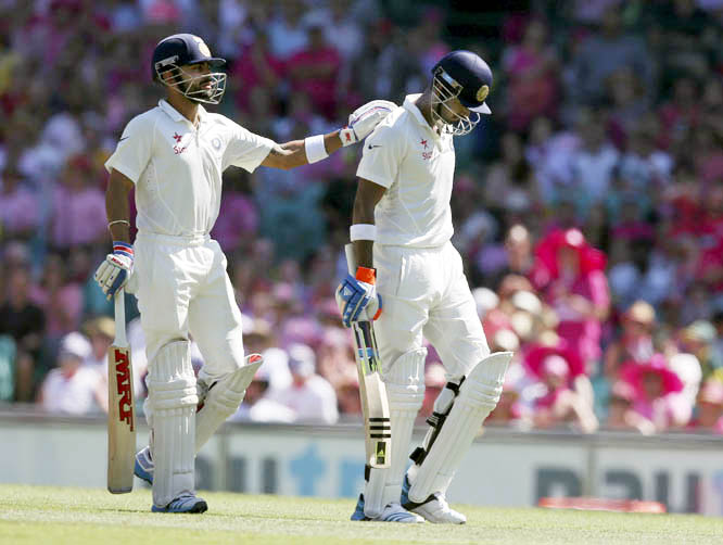 India's Lokesh Rahul (right) is patted on the back by his captain Virat Kohli after Rahul was caught out for 110 runs on the third day of their cricket Test match in Sydney, Australia on Thursday.