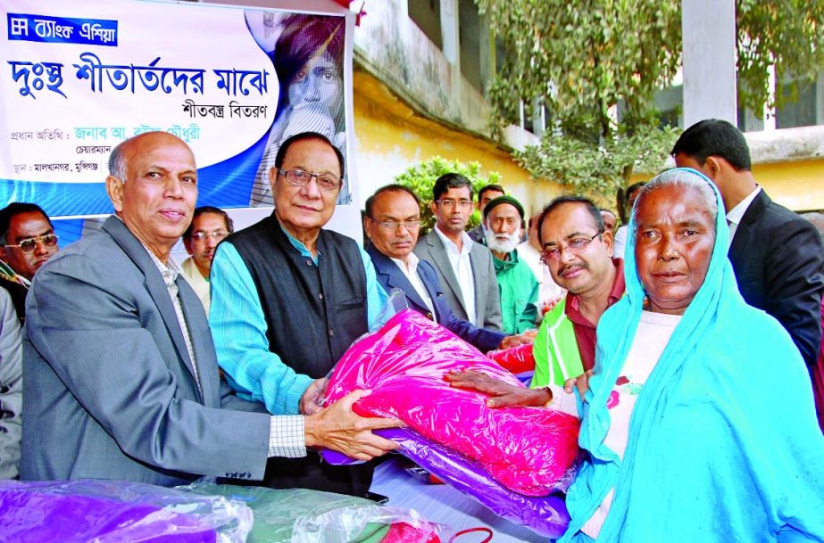 A Rouf Chowdhury, Chairman of Bank Asia Limited, distributing blankets among cold-hit poor at Malkhanagar of Sirajdikhan in Munshiganj recently.