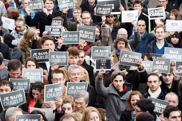 French residents hold signs reading "Je suis Charlie" (I am Charlie), to pay tribute to the victims of the Charlie Hebdo attack during a photo session at the Institut Francais in Tokyo