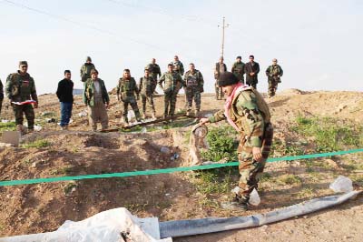 Kurdish Peshmerga forces inspect a site in Hardan village in northern Iraq, where Islamic State group fighters allegedly executed people from the Yezidi sect.