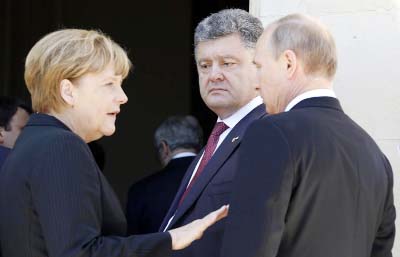 German Chancellor Angela Merkel (L), Ukrainian President-elect Petro Poroshenko and Russian President Vladimir Putin Â® speak at the D-Day 70th Anniversary ceremonies at Chateau de Benouville in Benouville, France