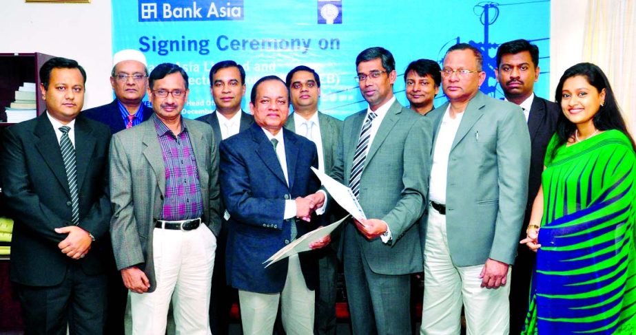 Md Arfan Ali, Deputy Managing Director of Bank Asia and ARM Harisul Rahman, Director Finance (FMT Department) of Bangladesh Rural Electrification Board (BREB) exchanging a deal document at BREB Bhaban in the city for collecting electricity bills through