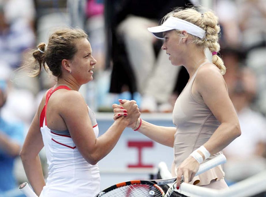 Caroline Wozniacki of Denmark (right) shakes hands with Barbora Zahlavova Strycova of the Czech Republic after retiring with an injury to her right wrist from their match at the Sydney International tennis tournament in Sydney on Monday.