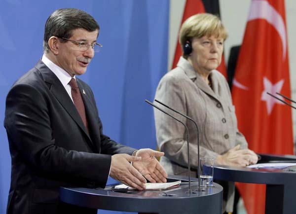 German Chancellor Angela Merkel, right, and the Prime Minister of Turkey Ahmet Davutoglu address the media during a joint press conference after a meeting at the chancellery in Berlin on Monday .