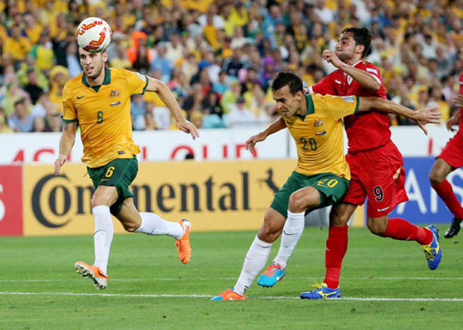Australia's Trent Sainsbury, center, and Oman's Abdul Aziz Al-Maqbali battle for the ball as Australia's Matthew Spiranovic, left, looks on during the AFC Asian Cup soccer match between Australia and Oman in Sydney, Australia on Tuesday.