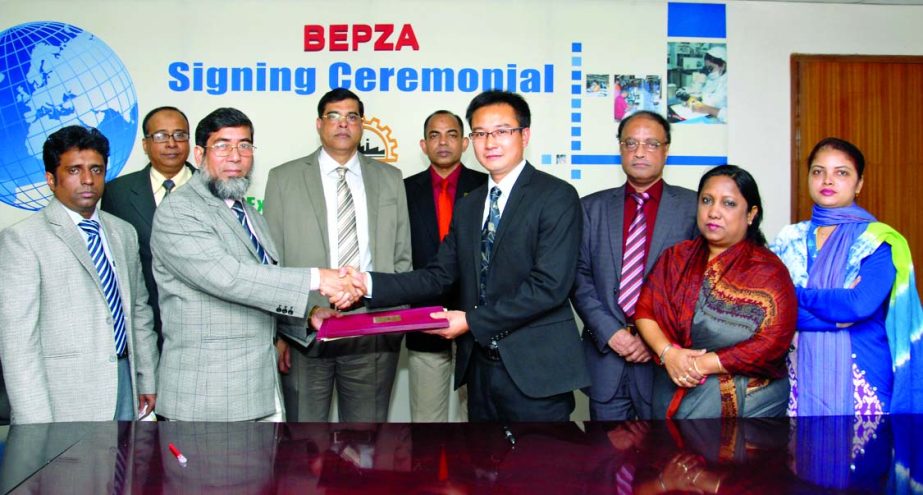 Sayed Nurul Islam, Member (Investment Promotion) of Bangladesh Export Processing Zones Authority and Zhai Hai Peng, General Manager of Ms Shanzhou (Bangladesh) Packing Ltd, sign an agreement at BEPZA Complex in the city to setup a Chinese Packing Materia