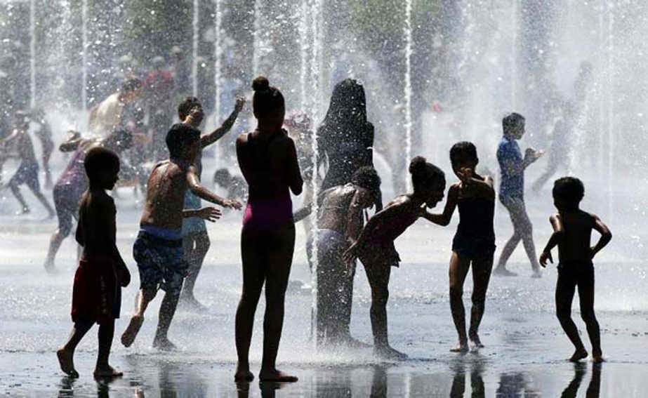 Photo shows children as they play in the water of a fountain on a hot summer day in Nice, southeastern France.