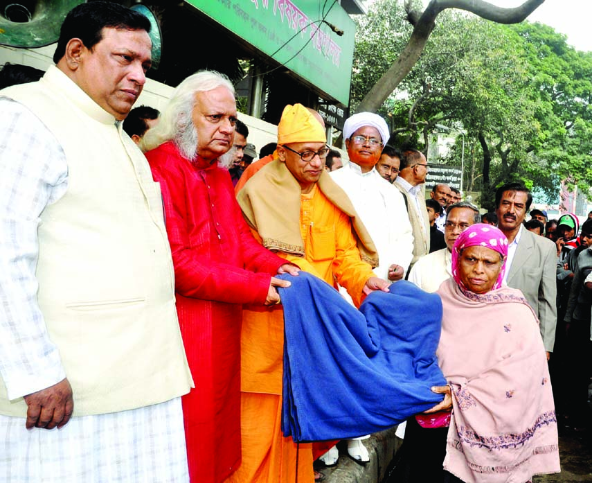Manoranjon Ghoshal, Secretary General of Inter Religious Harmony Society (IRHS) distributing warm clothes among the destitutes in front of the Liberation War Ministry gate in the city on Saturday. Nazmul Haque Prodhan, MP was also present on the occasion.