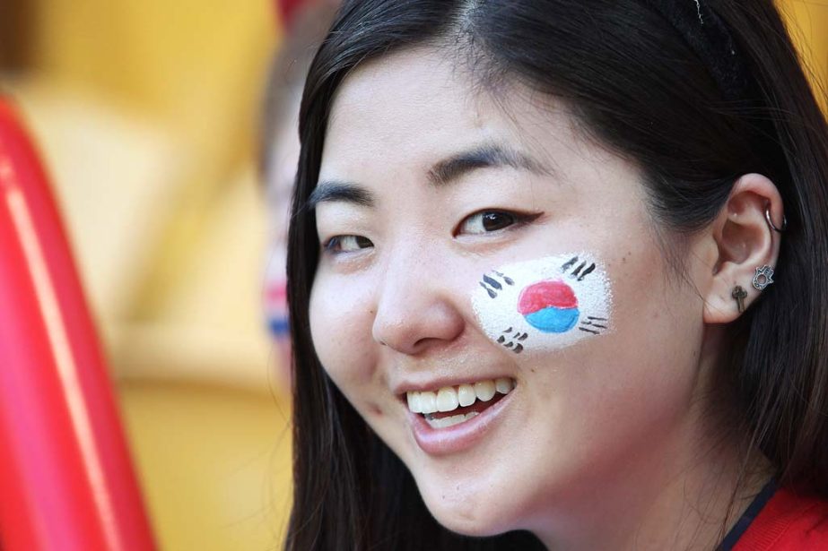 A South Korean fan with her country's national flag painted on her cheek smiles ahead of the AFC Asia Cup soccer match between Australia and South Korea in Brisbane, Australia on Saturday.