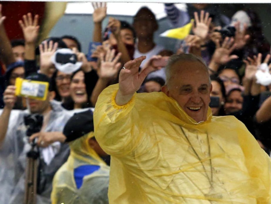 Pope Francis greets worshippers as he arrives to celebrate the mass.
