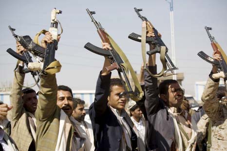 Houthi Shiite Yemeni raise their weapons during clashes near the presidential palace in Sanaa, Yemen on Monday.