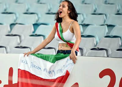 Woman fan's message: A fan of Iran cheers during their game against Qatar bearing "Will Alireza marry me?"""