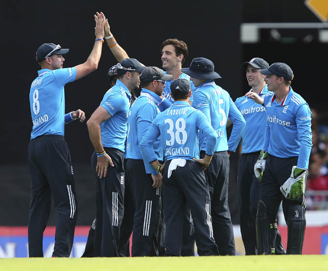 England's Steven Finn, center, without a cap, celebrates with his teammates after he got the wicket of India's MS Dhoni during the one day International cricket match between England and India in Brisbane, Australia on Tuesday.