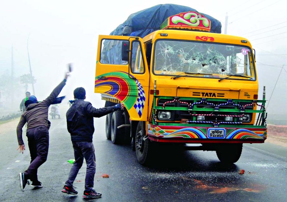 Pro-blockade activists vandalizing goods-laden truck at Jhopgari area in Bogra during blockade programme on Tuesday.