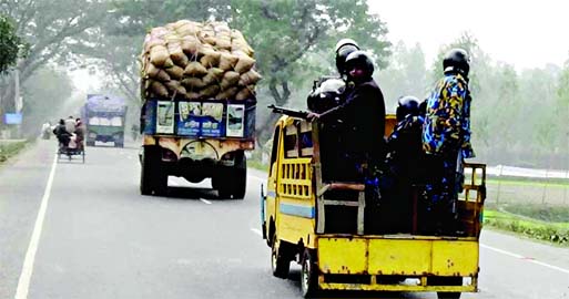 Police escorting goods laden trucks on way to Dhaka at Palashbari area on Rangpur Highway on Wednesday.