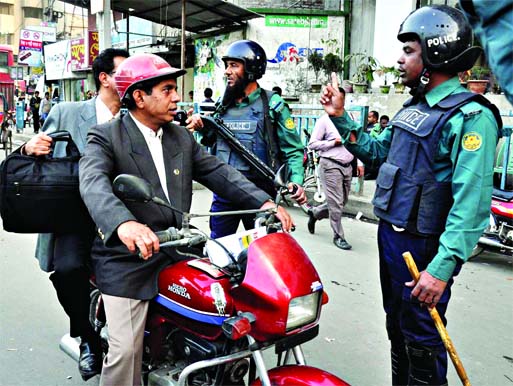 Traffic police stopped a motorbike rider and cautioned him about imposition of restriction on double riding with immediate effect. This photo was taken from Motijheel area on Thursday.