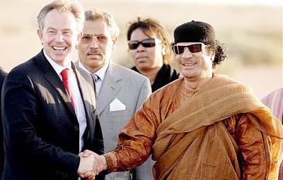 Tony Blair (L) smiles as he shakes hands with Colonel Muammar Abu Minyar al-Qaddafi on May 29, 2007 in Sirte, Libya.