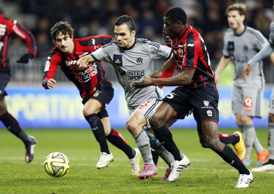 Marseille's Jeremy Morel (C) vies with Nice's Gregoire Puel (L) and Romain Genevois during a match in Nice, southeastern France on Friday.