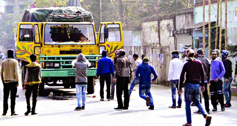 Blockade supporters vandalising a goods-laden truck at Fire Service inter-section in Rajshahi city on Sunday.