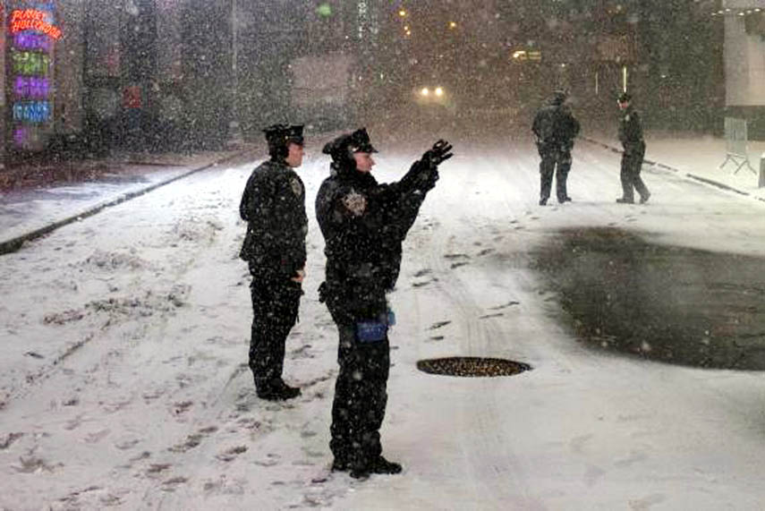 An New York Police Department officer takes photographs while keeping security during a snowstorm in Times Square, New York early morning on Tuesday.