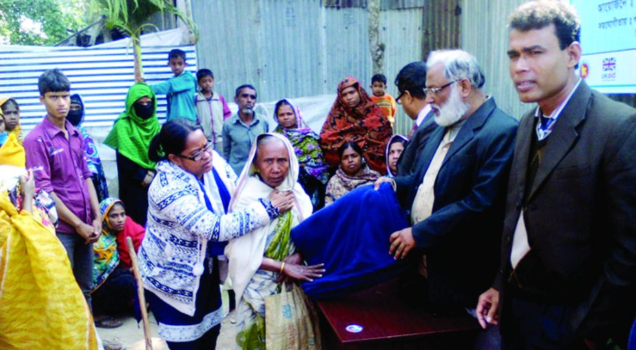 BETAGI (Barguna): Betagi Upazila Parishad Chairman Md Shahajahan Kabir distributing blankets among the ultra poor under Re-call Project with the assistance of Oxfam and Jagorani at Betagi Bus Stand on Monday. Mokamia UP Chairman Mahabub Alam Sujan, Sadar