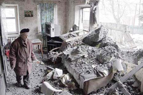 A woman surveys damage done to a house, which according to locals was recently damaged by shelling, in the suburbs of Donetsk on Friday.