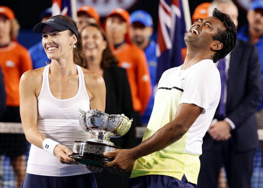 Martina Hingis of Switzerland (left) and Leander Paes of India hold trophy after defeating Kristina Mladenovic of France and Daniel Nestor of Canada in the mixed doubles final at the Australian Open tennis championship in Melbourne, Australia on Sunday.