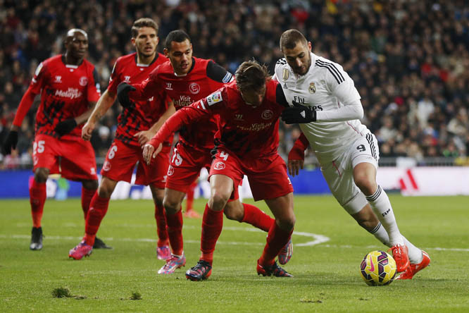 Real Madrid Karim Benzema (right) in action with Sevilla's Grzegorz Krychowiak (center right) during a Spanish La Liga soccer match between Real Madrid and Sevilla at the Santiago Bernabeu stadium in Madrid, Spain on Wednesday.