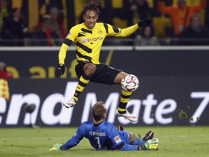 Augsburg's goalkeeper Alexander Manninger from Austria, (down) and Dortmund's Pierre-Emerick Aubameyang from Gabun challenge for the ball during the German first division Bundesliga soccer match between BvB Borussia Dortmund and FC Augsburg in Dortmund,