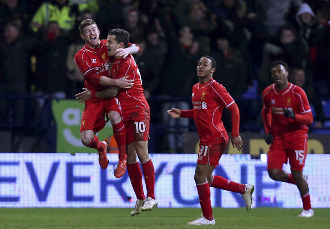 Liverpool's Philippe Coutinho (centre) celebrates with team-mates Alberto Moreno (left) and Raheem Sterling after scoring his side's second goal during their FA Cup Fourth Round Replay match at the Macron Stadium in Bolton, England on Wednesday.