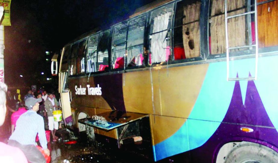 Fire Service men extinguishing fire on a night coach following a petrol bomb attack by pro-hartal activists in Pabna on Saturday night.