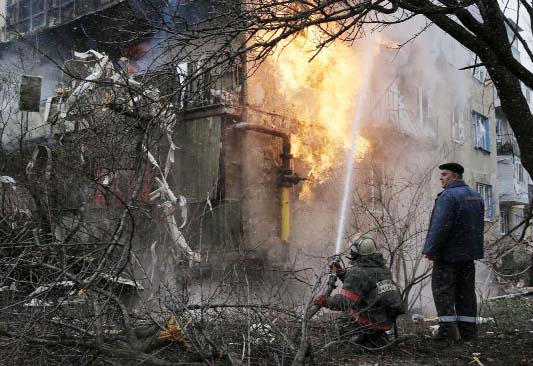 A firefighter works to extinguish a fire at a residential block, which was damaged by a recent shelling according to locals, on the outskirts of Donetsk, eastern Ukraine on Monday.