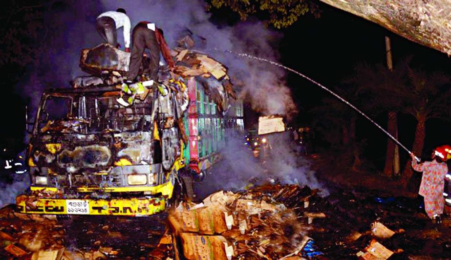 Fire fighters extinguishing fire at a goods-laden truck set ablaze by blockade supporters in city's Shahjadpur area under Badda thana on Tuesday.