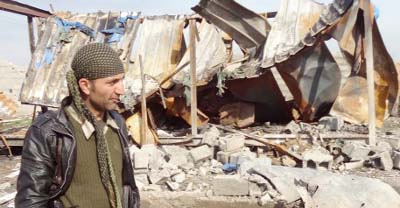 A member of the Iraqi Kurdish forces walks past a damaged building, near Al-Assal village, some 25 km West of the northern city of Kirkuk, a day after Peshmerga forces and police retook the area from Islamic State (IS) group.