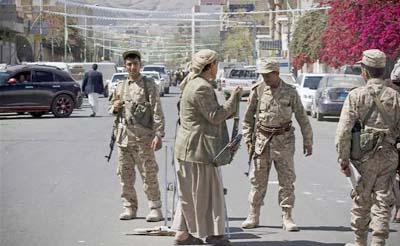 Houthi Shiite militants wearing army uniforms stand guard on a street leading to the presidential palace in Sanaa.