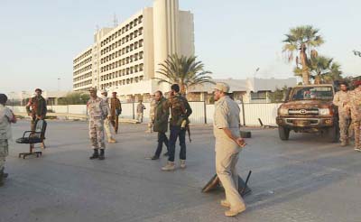 Libyan military personnel stand at a checkpoint in the city center in Benghazi.