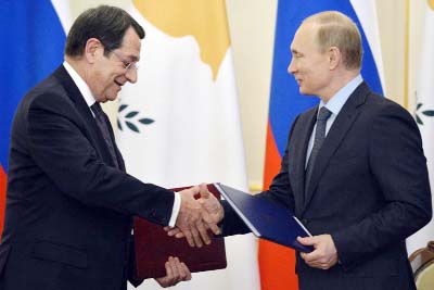 Russian President Vladimir Putin, right, and Cyprus' President Nicos Anastasiades shake hands as they exchange documents at a signing ceremony in the Novo-Ogaryovo residence outside Moscow, Russia on Wednesday.