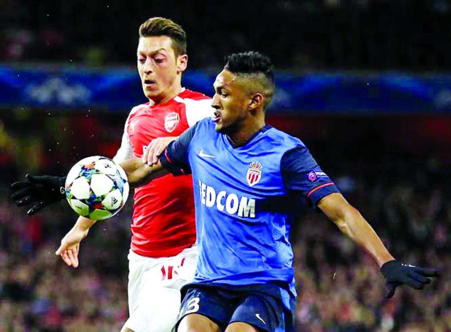 Arsenal's Mesut Ozil (left) challenges Monaco's Wallace during the Champions League round of 16 soccer match between Arsenal and AS Monaco at the Emirates Stadium in London on Wednesday.