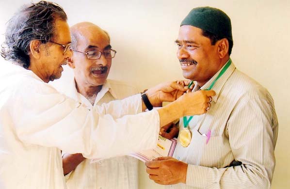 Md Abdur Rahim, General Secretary, Jatiya Char Nata Smriti Parishad receiving life-time achievement award at a function at Shishu Academy in the city from Harendra Nath Gotishasri , President , SAARC Cultural Forum in the city recently.