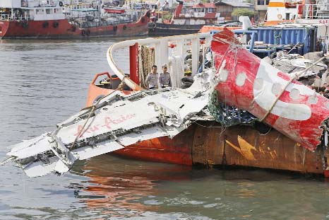 Wreck: Police officers examine the newly-recovered remains of the fuselage of AirAsia Flight 8501 on the deck of rescue ship Crest Onyx at Tanjung Priok port in Jakarta, Indonesia. Authorities say this is the last big piece of the ill-fated passenger jet