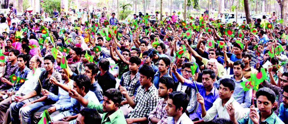 A section of students rendering songs by hoisting national flags at the foot of Aparajeya Bangla of Dhaka University on Monday marking Independence Flag Hoisting Day.