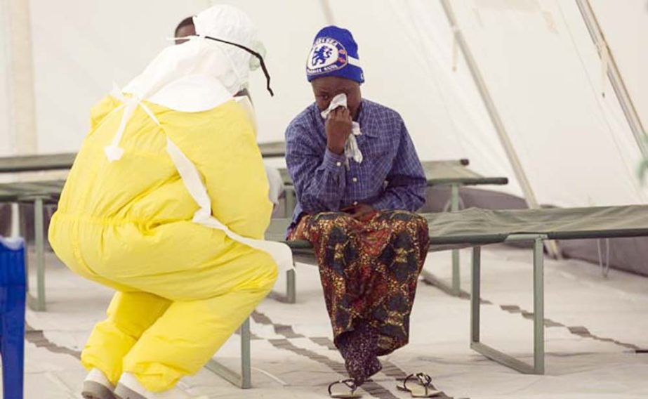 A health worker wearing protective gear tends to a newly admitted suspected Ebola patient in a quarantine zone at a Red Cross facility in the town of Koidu, Kono district in Eastern Sierra Leone.