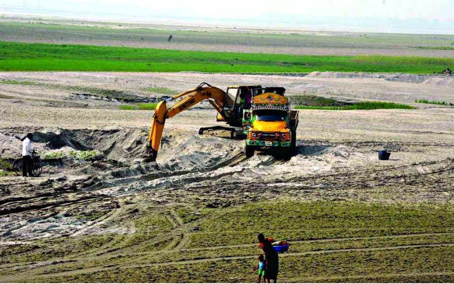 Sand business continues unabated illegally occupying Jamuna River bank areas despite ban order by Court. This photo was taken from Nehalpur point in Manikganj on Wednesday.