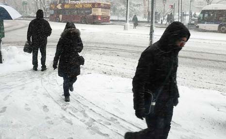 Pedestrians walk through the snow in New York City on Thursday.