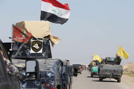 Members of the Iraqi security forces drive towards al-Dawr area, located south of Tikrit, to launch an assault against the Islamic State group.