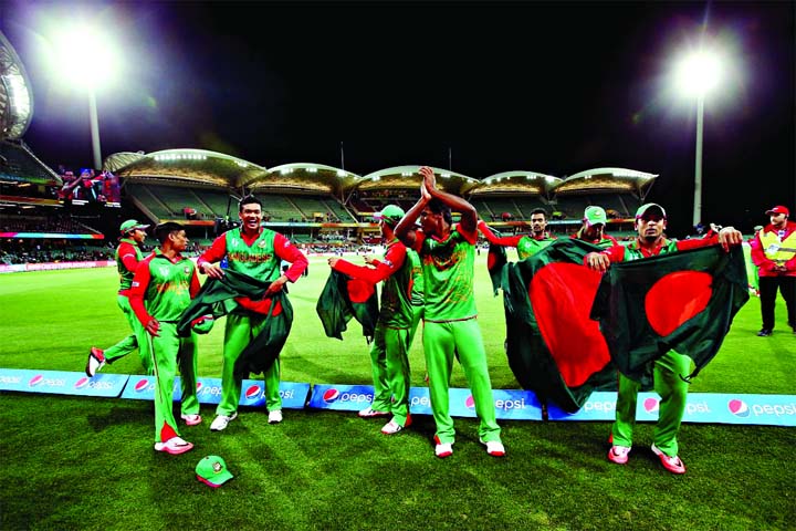 Players of Bangladesh celebrate with the national flag of Bangladesh after defeating England in their Pool A match of the ICC World Cup Cricket 2015 at the Adelaide Oval in Adelaide, Australia on Monday.