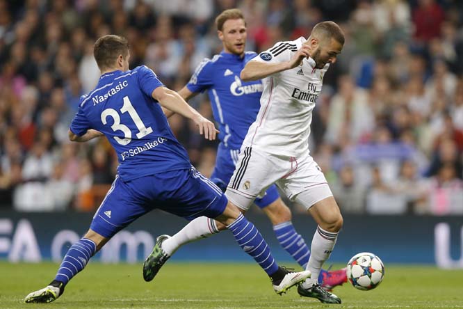 Real Madrid's Karim Benzema (right) passes Schalke's Matija Nastasic, left, during a Champions League soccer match round of 16 second leg, between Real Madrid and Schalke 04 at Santiago Bernabeu stadium in Madrid, Spain, on Tuesday.