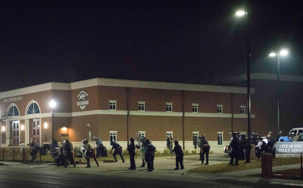 Police stand guard moments after two officers were shot during a protest outside the Ferguson police department. Photo: Reuters